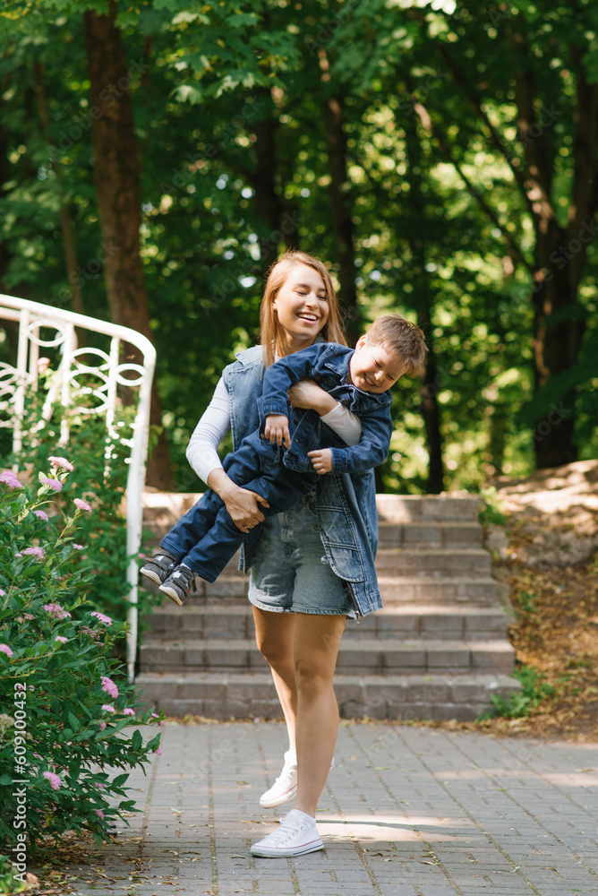 Fototapeta premium Caucasian mom having fun with her little son in the summer in the park
