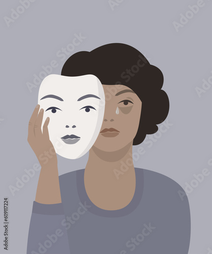 Sad woman hiding behind a mask. Concept of masking in psychology. 