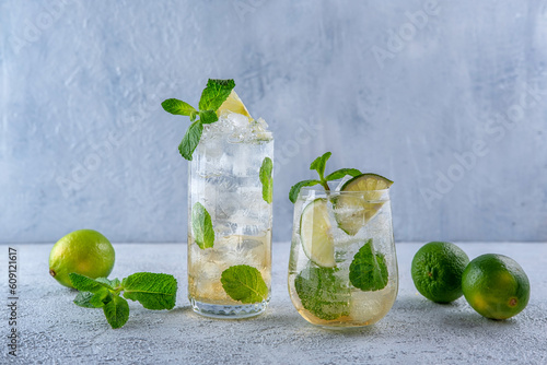 Cocktail Mojito. Cocktail with rum, mint, lime and ice in a glass on a grey background. Homemade beverage.