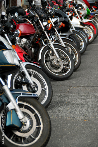 Row of motocycles parked on a street in front a motorcycle store