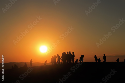 silhouette of people at sunset in desert © Neha