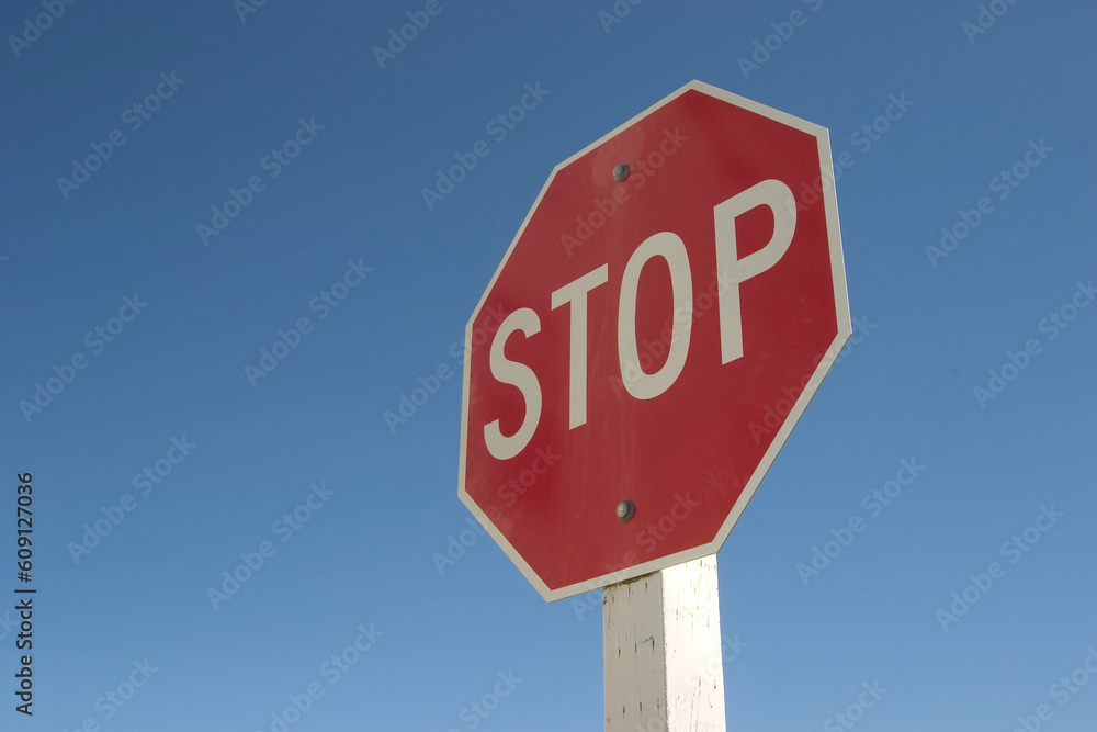 A authoritatively low angle view of stop sign against a very blue sky. A authoritatively low angle view of stop sign against a very blue sky.