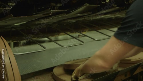 static medium shot of a worker arranging cocoa discs in a chocolate factory