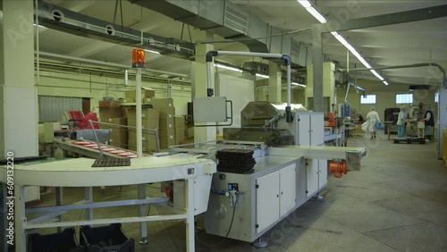 static wide shot of chocolates in a package on a conveyor line in a chocolate factory
