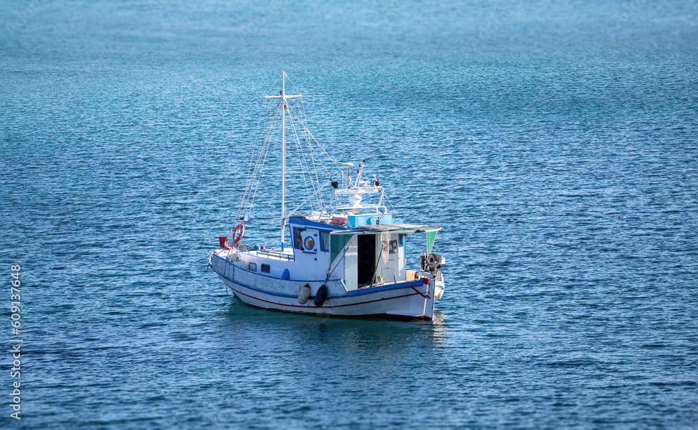 Traditional fishing boat, trawler moored, rippled sea water background, Greece Traditional fishing boat, trawler moored, rippled sea water background, Greece