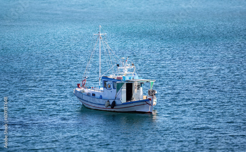 Traditional fishing boat, trawler moored, rippled sea water background, Greece
