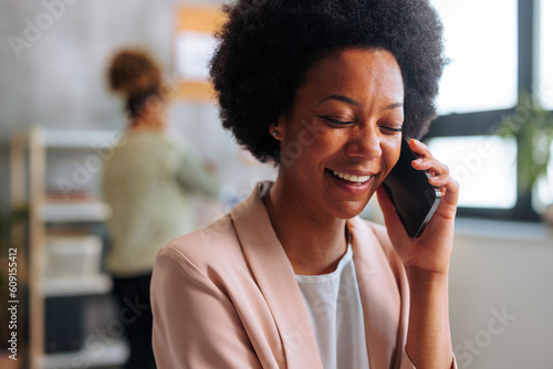 Portrait of young African-American woman laughing while having phone call.