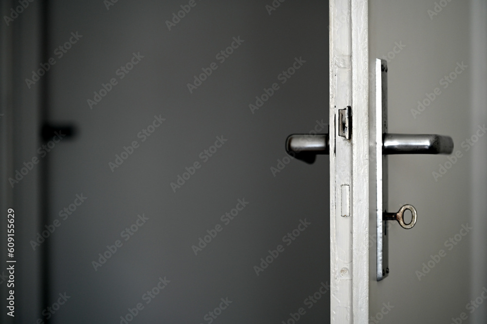 Old open door with a lock, key and handle visible Old open door with a lock, key and handle visible
