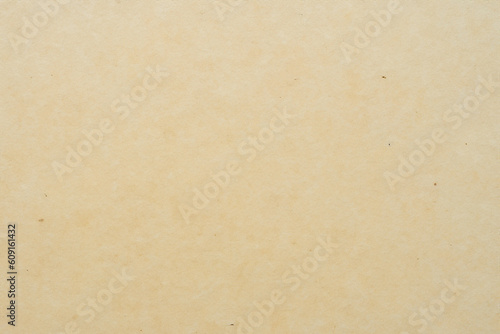 Smooth mustard or beige background, warm tones, texture of old paper or wallpaper with some stains and small tears.