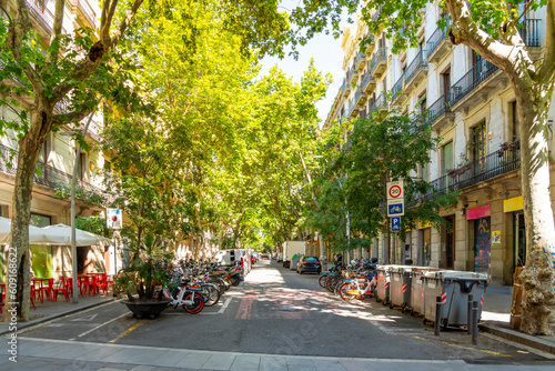 A tree lined street of shops in the L'Eixample district near Ciutadella Park in Barcelona, Spain.