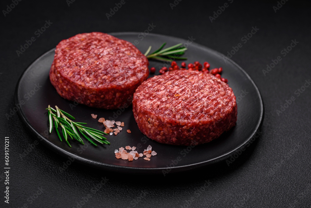 Fresh raw ground beef burger patty with salt and spices Fresh raw ground beef burger patty with salt and spices