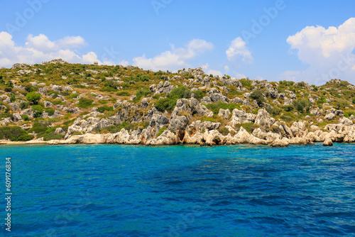 Fototapeta Naklejka Na Ścianę i Meble -  View of the rocky shore from the sea. Mediterranean Sea in Turkey. Popular tourist places. Background