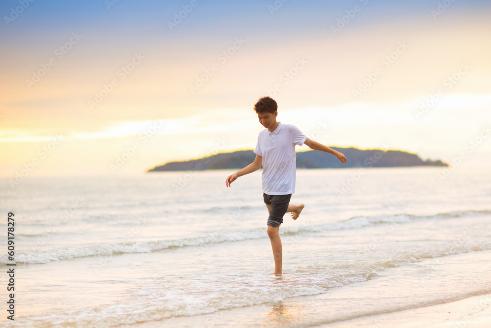 Teenager playing on ocean beach.