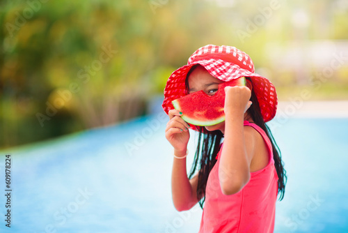 Child with watermelon in swimming pool