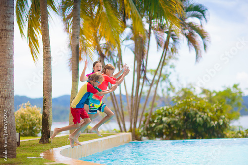 Kids jump into swimming pool. Summer water fun. © famveldman