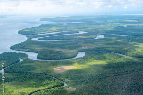 Coastline and river systems on a flight to the tip of Australia, Cape York, Queensland. Aerial photo of winding rivers and horizon in wild crocodile country.