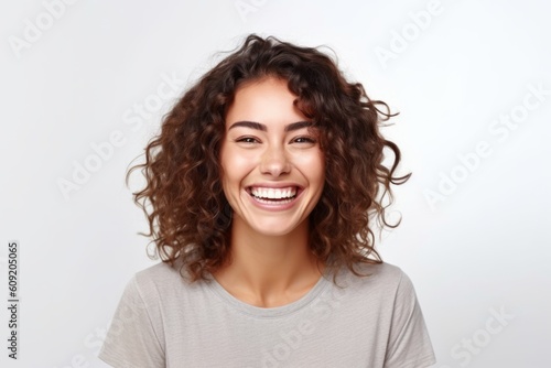 Portrait of a happy young woman with curly hair over white background © Robert MEYNER