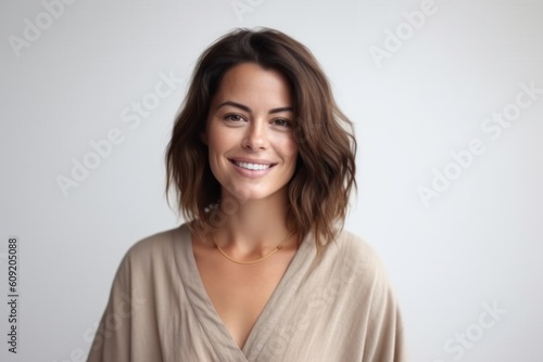 Medium shot portrait photography of a satisfied woman in her 30s that is wearing a simple tunic against a white background . Generative AI