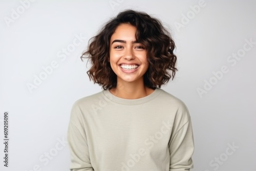 Portrait of a smiling young woman with curly hair isolated on a white background