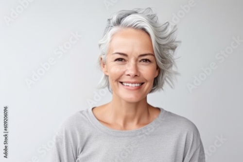 Portrait of a smiling mature woman with grey hair isolated on a white background