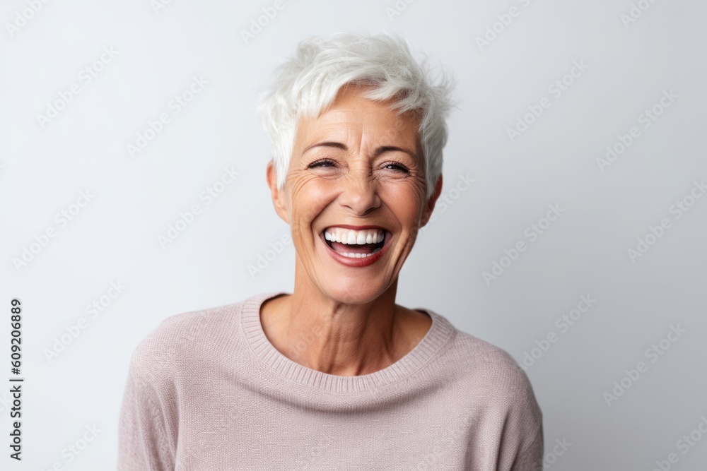 Portrait of a happy senior woman laughing while standing against white background Portrait of a happy senior woman laughing while standing against white background