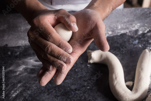 Primer plano a las manos del panadero mientras prepara la masa para hornear pan.