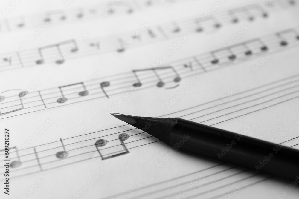 Fototapeta premium Sheet with musical notes and pencil, closeup view