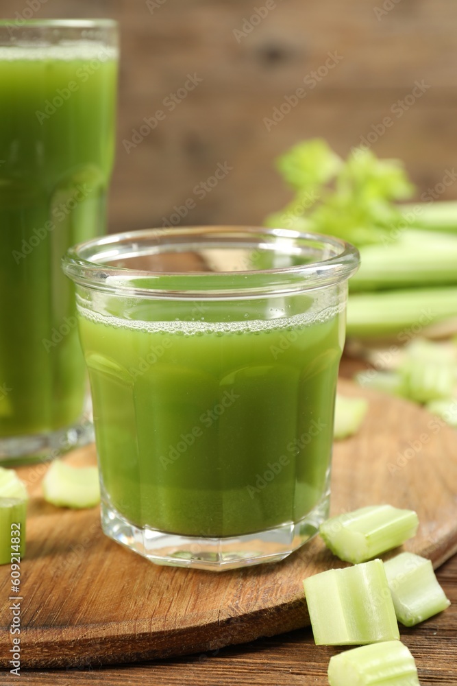 Glass of celery juice and fresh vegetable on wooden table, closeup Glass of celery juice and fresh vegetable on wooden table, closeup