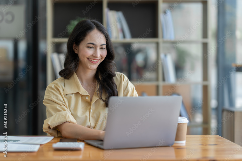 Confident Asian businesswoman using laptop calculator Paperwork for financial work, calculations on the desk, tax, report, accounting, statistics. Analytical research concept. Confident Asian businesswoman using laptop calculator Paperwork for financial work, calculations on the desk, tax, report, accounting, statistics. Analytical research concept.