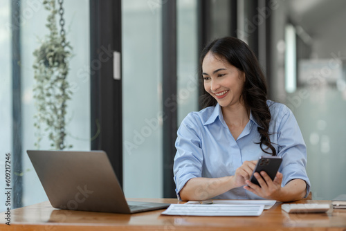 Confident businesswoman working using mobile phone to search for information Talk through an application about financial investments in real estate business projects. management system concept.