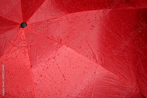 Close up of a wet, red umbrella. Abstract graphic image, suitable for background.
