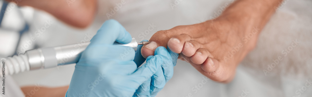 Perdicure master polishes toenail of client with grinding tool at procedure in salon Perdicure master polishes toenail of client with grinding tool at procedure in salon