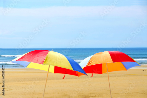 Two beach ubrella standing on ocean shore