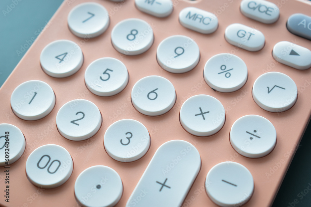 close up modern peach colour pastel calculator and white button on blue background, business and finance accounting concept close up modern peach colour pastel calculator and white button on blue background, business and finance accounting concept