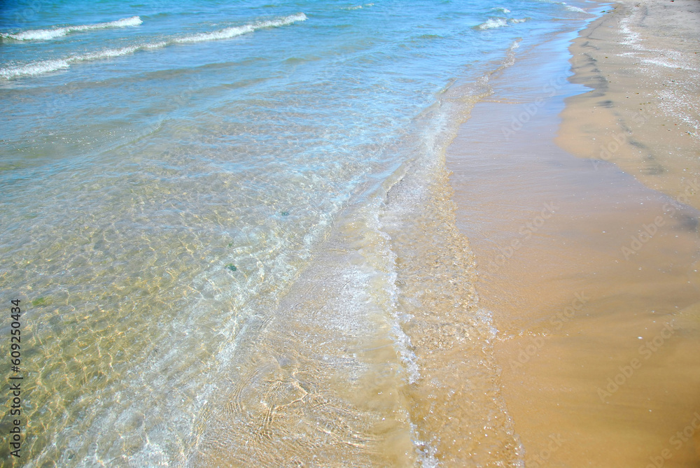 Waves on sandy beach closeup