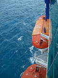 orange covered lifeboats, shipside above the caribbean