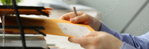 Person picks up yellow envelope with mail at workplace. Types of business correspondence concept photo