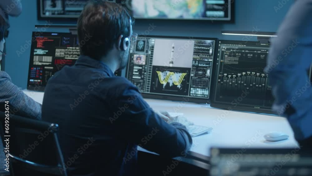 Flight control operators in headsets monitor space mission on computer in mission control center. Group of workers clap hands after successful space rocket launch displayed on monitors and big screen. Flight control operators in headsets monitor space mission on computer in mission control center. Group of workers clap hands after successful space rocket launch displayed on monitors and big screen.