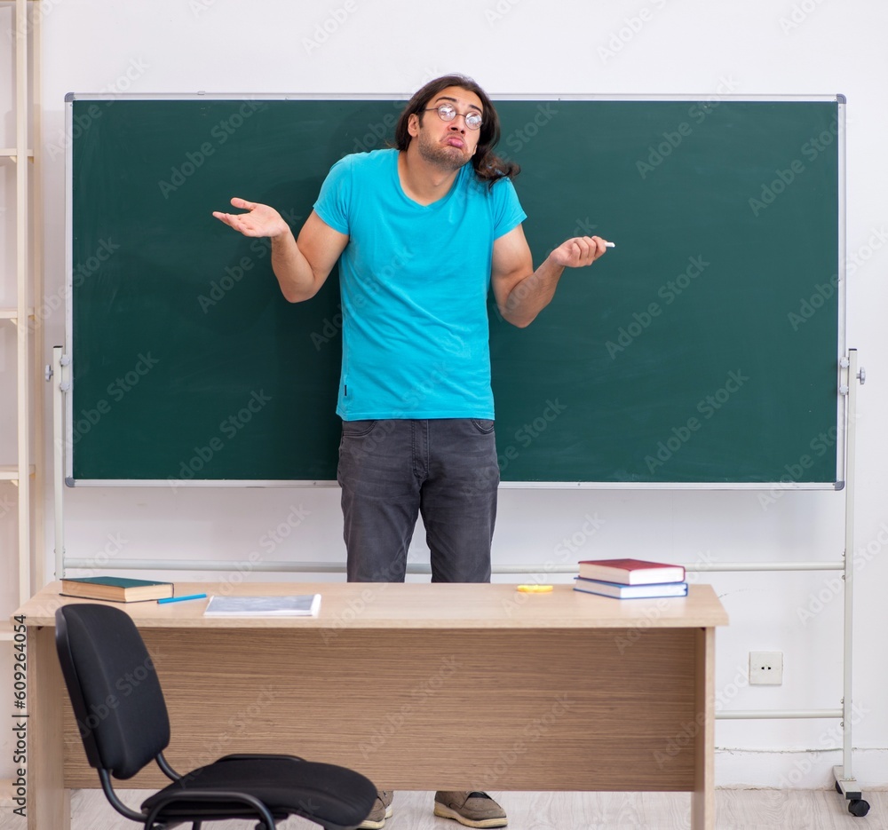 Young male student in front of green board Young male student in front of green board