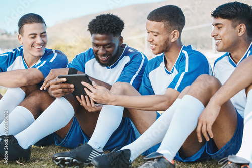 Soccer player, team or group with a tablet outdoor on field for fitness training or online game. Football, club and diversity athlete people or friends with tech to watch sports competition or video