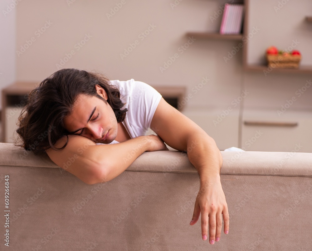 Young lazy man in oversleeping concept at home Young lazy man in oversleeping concept at home
