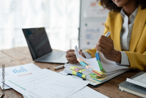 Bilde på lerret African American businesswoman searching through piles of paperwork for financial, tax, accounting documents on her desk to prepare to explain and clarify at management concept meeting