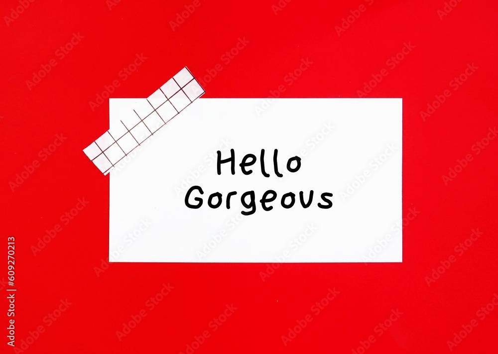 Note stick on red background with handwritten text HELLO GORGEOUS, nice