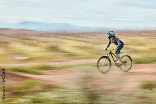 Fitness  adrenaline and man riding a bike in nature training for a race  marathon or competition. Sports  motion and male athlete biker practicing for an outdoor cardio exercise  adventure or workout