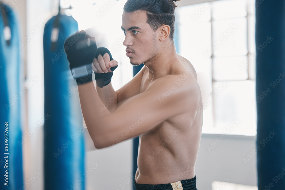Sports, boxing and man punch for mma fight in gym for training, workout and martial arts exercise. Fitness, body builder and serious male athlete ready for boxer competition, practice and performance Sports, boxing and man punch for mma fight in gym for training, workout and martial arts exercise. Fitness, body builder and serious male athlete ready for boxer competition, practice and performance