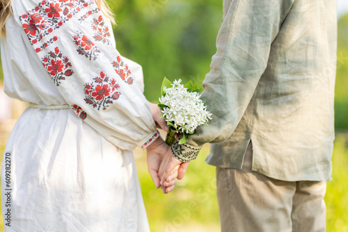 Young ukrainian couple in embroidered national shirts holding hands. Man and woman ouydoor. Lovers, family, trust, love and happiness concept. photo