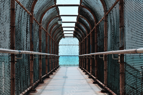 small fenced city bridge connecting one side of the street to another 