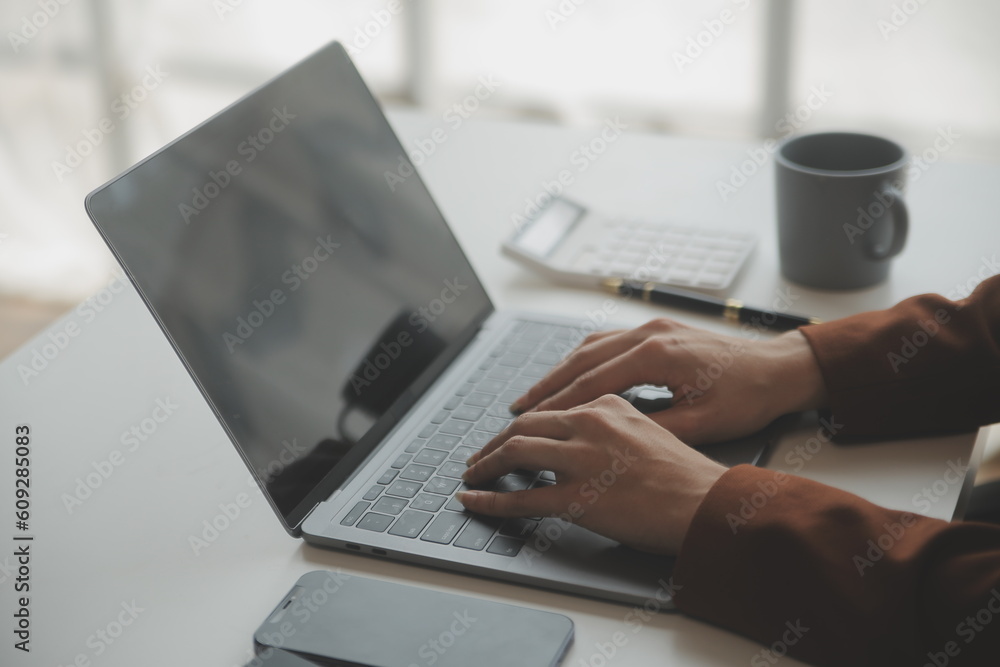 Close up Business woman using calculator and laptop for do math finance on wooden desk, tax, accounting, statistics and analytical research concept Close up Business woman using calculator and laptop for do math finance on wooden desk, tax, accounting, statistics and analytical research concept