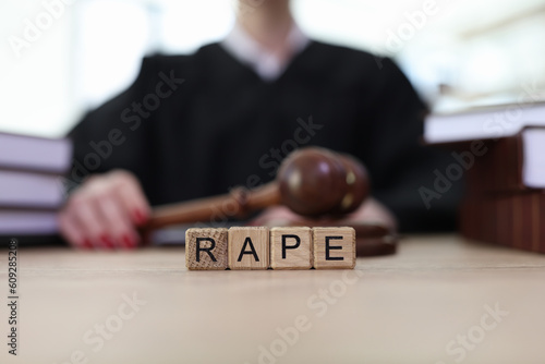 Fotografie Text Rape on cubes on wooden judge counter in courtroom