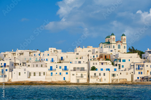 Obraz na płótnie Greek whitewashed houses and church by seafront on sunny day, Naoussa w salonie